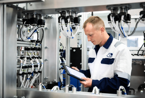 Maintenance professional using checklist to inspect custom cables on machinery, supporting better total cost of ownership decisions