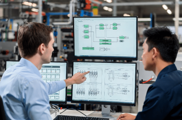 Control engineer and technician discussing custom cable specifications and network topology diagrams for PROFINET EtherCAT systems in automation factory