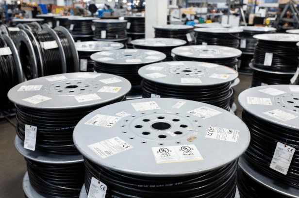 Cable reels in factory showing visible UL, CE, RoHS, TÜV certification labels for compliance in overseas custom cable sourcing