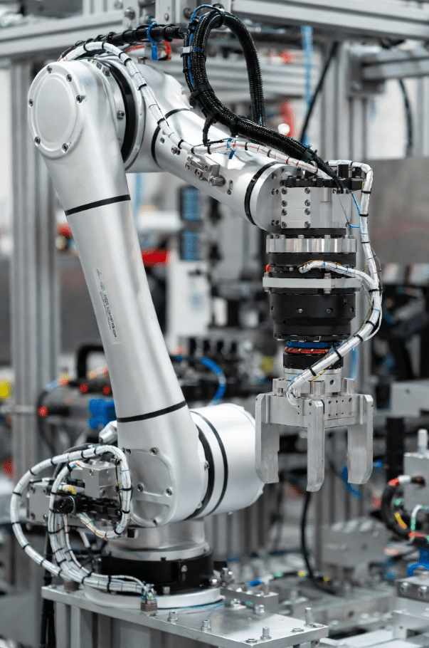 Professional view of a compact 6-axis robot arm showing torsion cables routed through narrow internal channels and rotary joints, highlighting space-constrained design for reliable robotic motion
