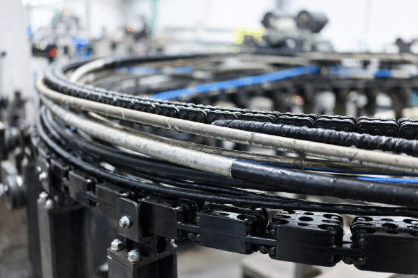 Professional view of drag chain cables showing various jacket materials inside a moving cable carrier in industrial automation equipment, highlighting flexibility and wear resistance for drag chain applications