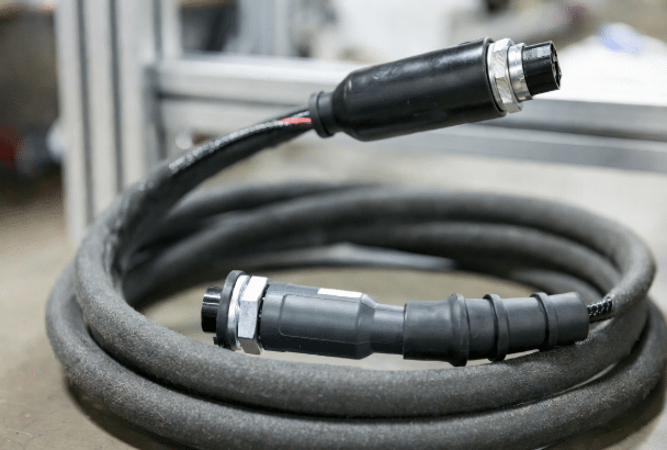 Close-up of abrasion-resistant TPE/PUR jacket on high-flex custom cables with IP-rated connectors suitable for dusty and high-motion warehouse environments