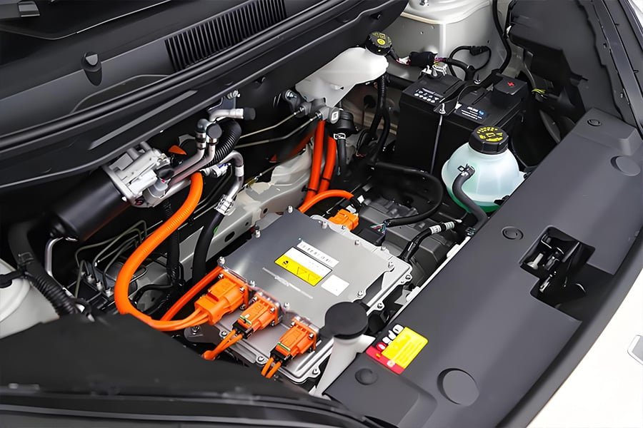 Orange high-voltage cables routed in an electric vehicle engine bay, demonstrating compliance with automotive safety standards for EV powertrain systems
