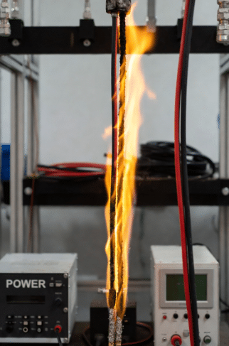 Professional lab photo of flame-retardant silicone cables during VW-1 flame testing showing controlled performance with low smoke, highlighting safety features for appliance and heating equipment
