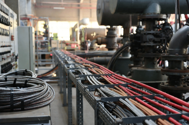 Professional close-up of bundled flame-retardant high-temperature silicone cables installed near machinery in a clean factory environment, highlighting flexible construction and safety-focused design for industrial applications