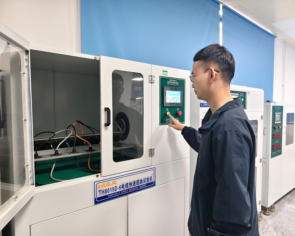 HULK TH8015D-6 Cable Bending Tester in lab environment, with technician operating control panel to test multi-core cables under high-frequency flexing, validating durability for robotics and drag chain applications.