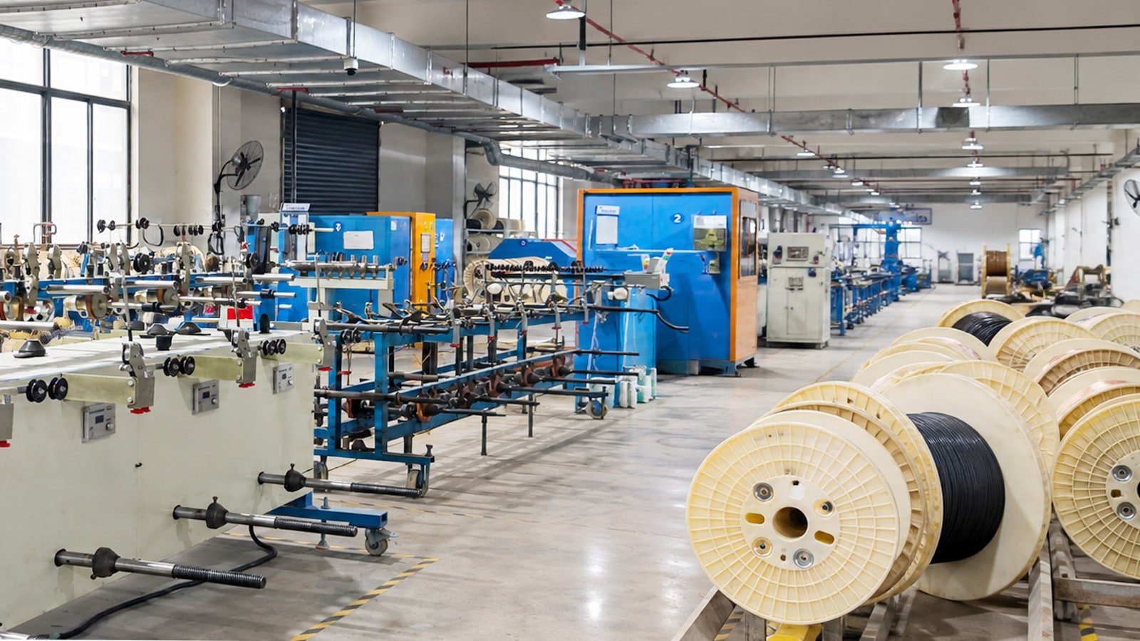 HULK cable manufacturing facility showing automated production lines and large plastic reels with finished black industrial cables, highlighting scalable and precision-driven manufacturing for automation and robotics applications.