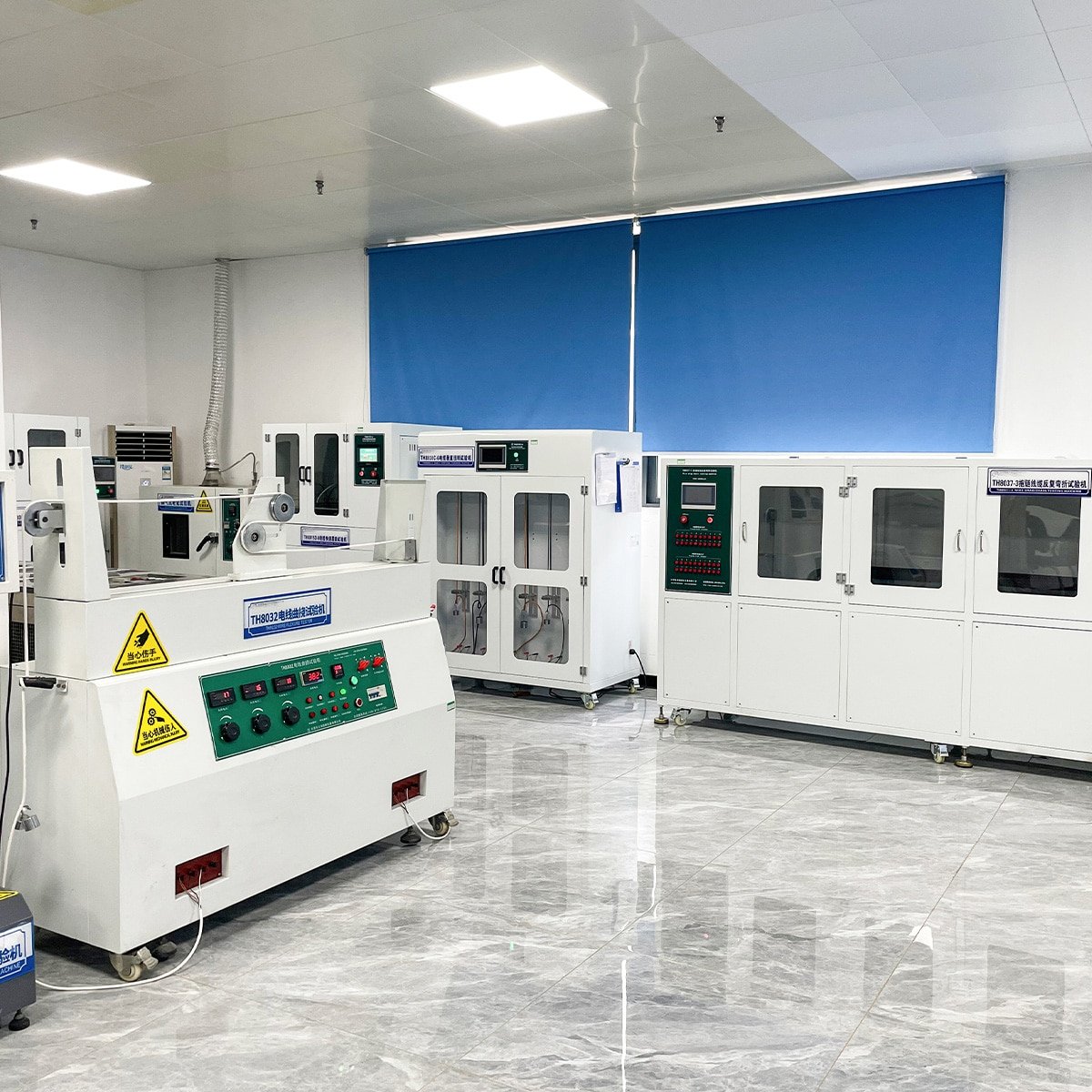 Inside HULK's quality control laboratory featuring specialized cable testing equipment, including a green-panel bending tester and white environmental aging chambers, ensuring strict compliance and durability standards for industrial cables.