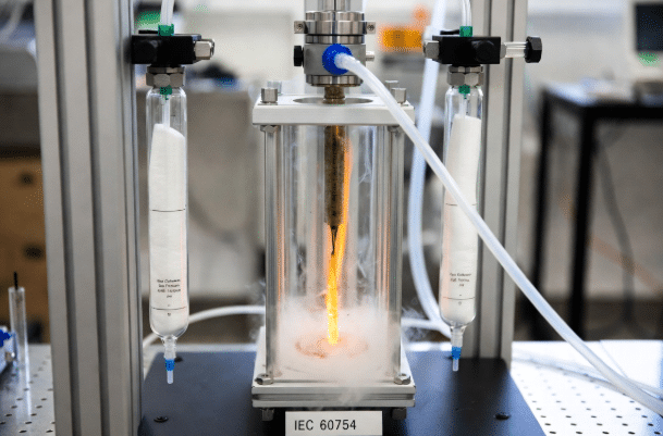 Detailed lab photo of IEC 60754 halogen acid gas test apparatus measuring emissions from cable samples, demonstrating compliance testing for low-corrosion halogen-free materials