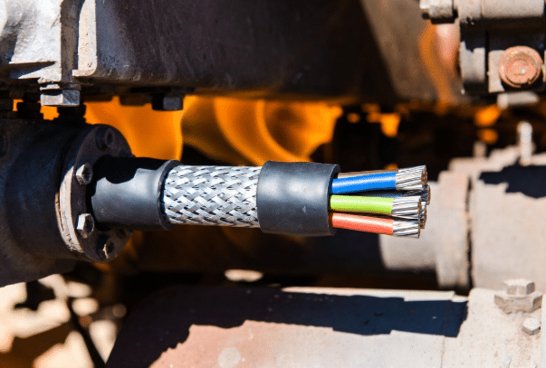 Close-up of durable high-temperature custom silicone cable installed near hot industrial machinery, showing robust construction and reliable performance in demanding conditions for automation applications