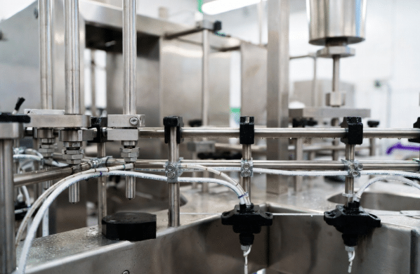 Stainless steel food and beverage processing machinery with high-flex custom cables and washdown-rated cordsets routed cleanly, showing durability in a hygienic plant environment with visible water from cleaning