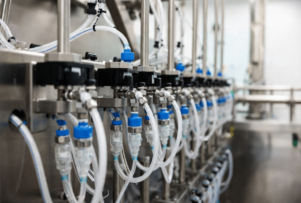Close-up of food-grade sensor and actuator cables with IP69K connectors installed on stainless steel processing machinery in a hygienic food production line, showcasing clean routing and washdown-resistant design