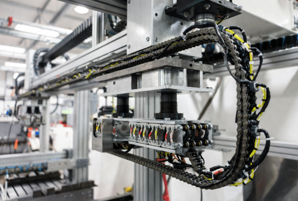 Realistic view of open drag chain cable carrier with multiple custom flexible cables installed in an industrial automation machine, highlighting continuous motion routing for drag chain applications