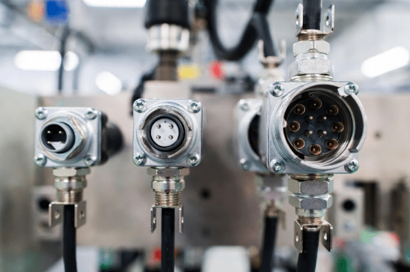 Side-by-side comparison of M8 and M12 sensor connectors mounted on automation equipment showing size difference, threading, and industrial application context for choosing the right circular connector
