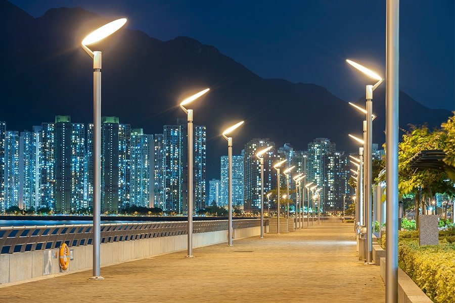Modern LED streetlights illuminating a waterfront promenade at night, illustrating potential outdoor cable applications for smart city infrastructure projects