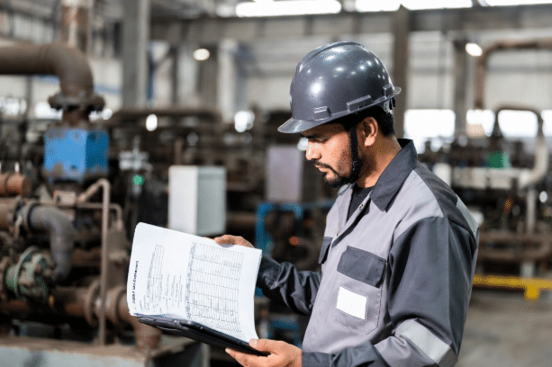 Maintenance engineer in industrial setting examining cable datasheets and temperature data to select appropriate silicone cable for high-temperature plant applications