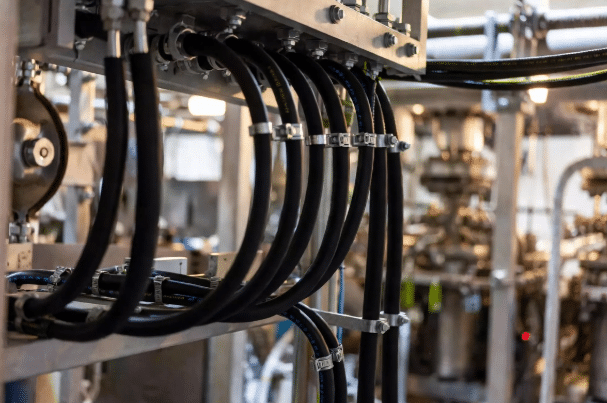 Realistic industrial installation of silicone cables demonstrating minimum bend radius, clamping, and secure routing in high-temperature process equipment to ensure mechanical reliability