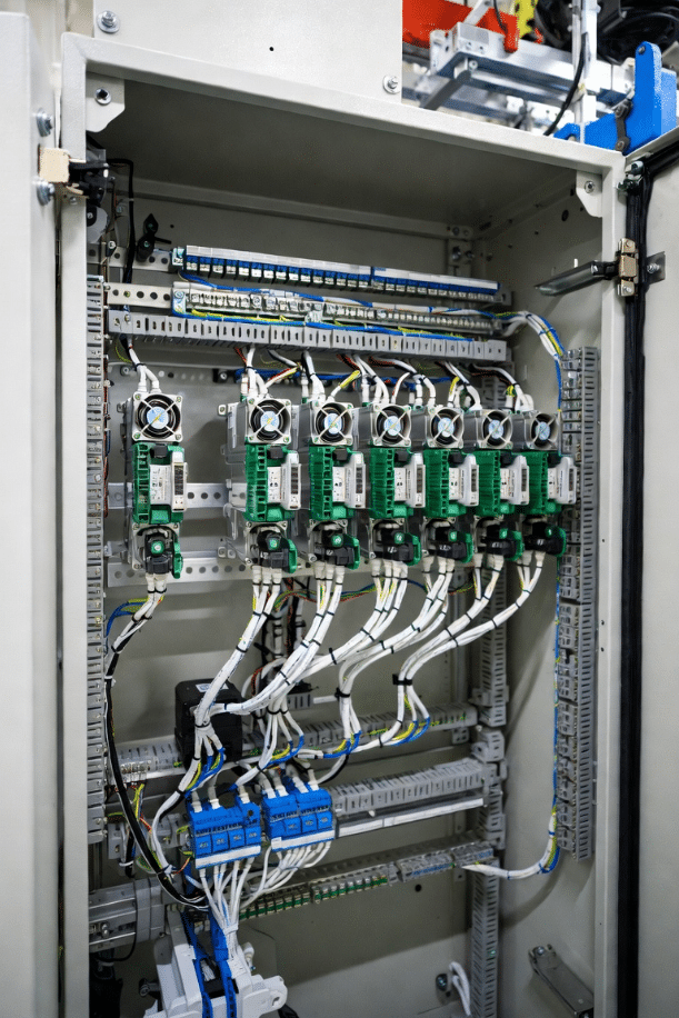 Close-up inside robot control cabinet highlighting proximity of high-power drives to shielded signal cables, demonstrating EMI risks in high-EMI robotic applications