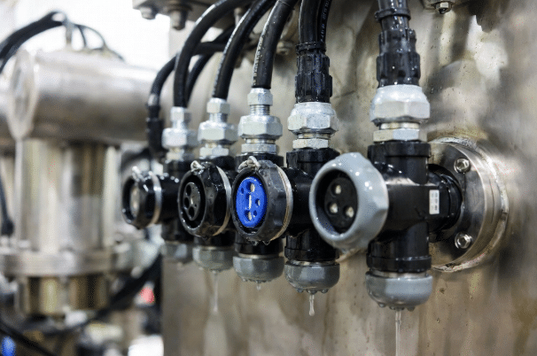 Annotated technical illustration showing proper IP-rated sensor cable gland sealing, drip loop routing, and common water ingress paths in harsh industrial environments
