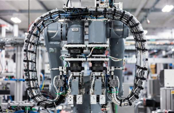 Industrial six-axis robot arm highlighting cable routing and dress packs, contrasting restrictive bundling versus proper segmented management for torsion-resistant robot cables in automation