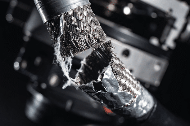 Macro photograph of failed braid and foil shielding on robot cable due to excessive torsion, highlighting importance of proper specification for high-EMI robotic applications