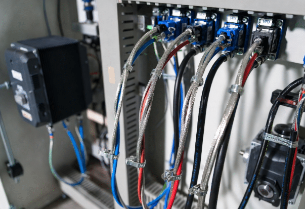 Professional view of VFD inverter panel connected with shielded servo motor cables, grounding straps, and EMC clamps highlighting best practices for reducing bearing currents in inverter-driven systems
