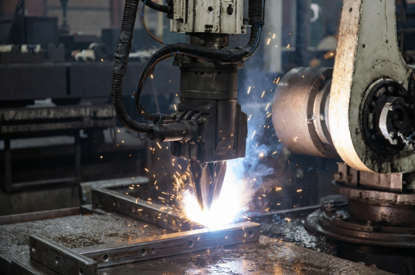 Welding robot in action with weld spatter and oil present, torsion cables protected by robust jackets suitable for thermal and chemical challenges