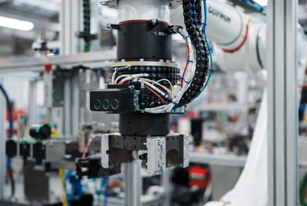 Robot arm equipped with machine vision camera and continuous-flex torsion cables routing through dynamic motion path in industrial automation