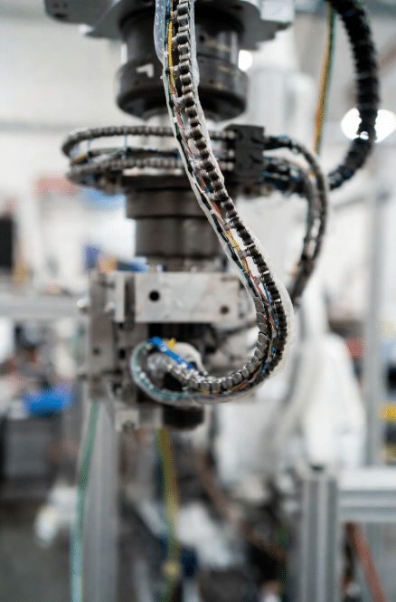Close-up of drag chain cable under torsional and multi-axis bending stress in six-axis robotic arm, demonstrating need for custom torsion-resistant design in advanced automation