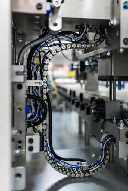 Tight installation of custom hybrid drag chain cables in space-constrained packaging equipment, showing optimized layout to meet strict bend radius and clearance requirements