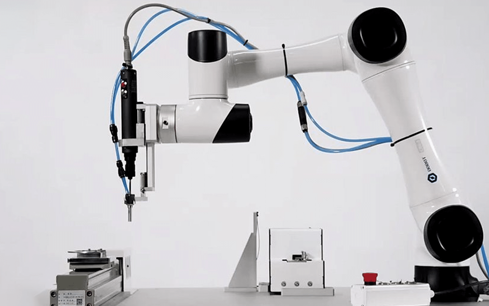 A white collaborative robot arm performing precision assembly with blue HULK high-flex cables routed along its joints; the cables feature low-friction, halogen-free insulation and compact diameter, enabling safe human-robot interaction in light automation tasks like electronics assembly or lab automation.