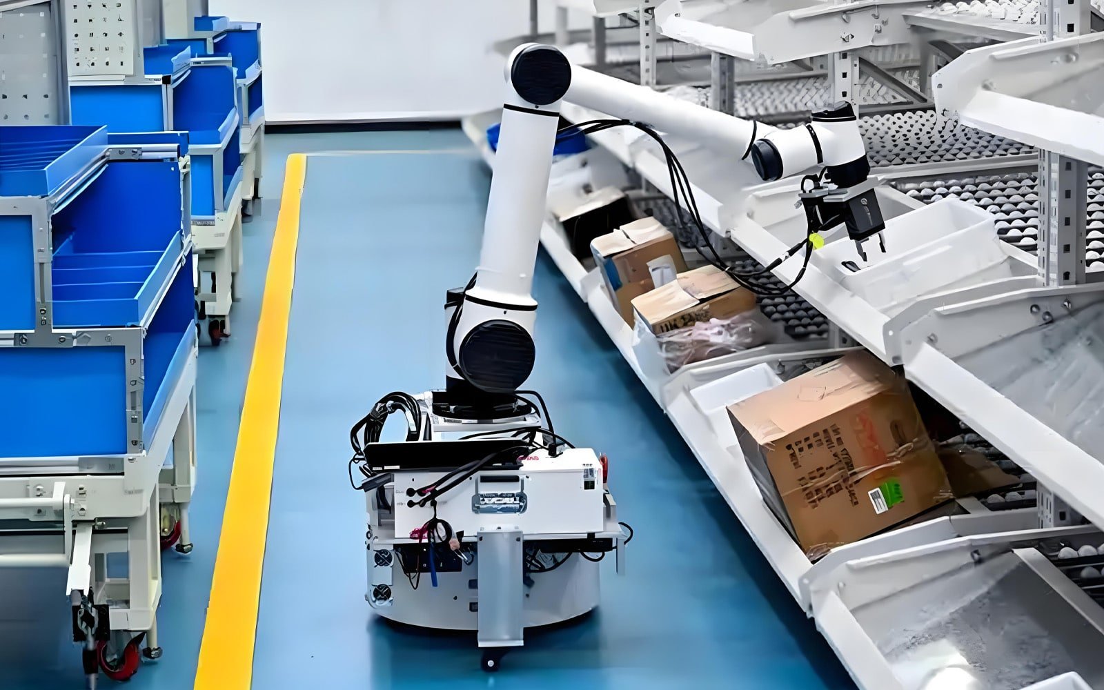 A white mobile composite robot (AMR with collaborative arm) performing parcel sorting in a smart warehouse, with black HULK high-flex cables routed along its base and arm; the cables are engineered to withstand combined motion of navigation, lifting, and grasping, ensuring stable power and data transmission under vibration and impact in dynamic logistics environments.