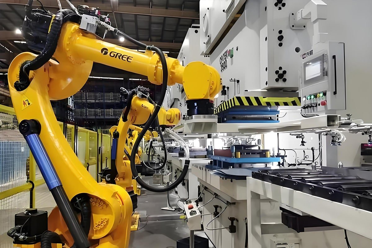 HULK industrial-grade cables integrated into yellow GREE six-axis robot arm operating in heavy-duty stamping/welding cell; cables withstand high vibration, frequent bending, and EMI while ensuring stable data and power transmission between robot and large-scale machinery — engineered for durability and compatibility in extreme manufacturing environments.