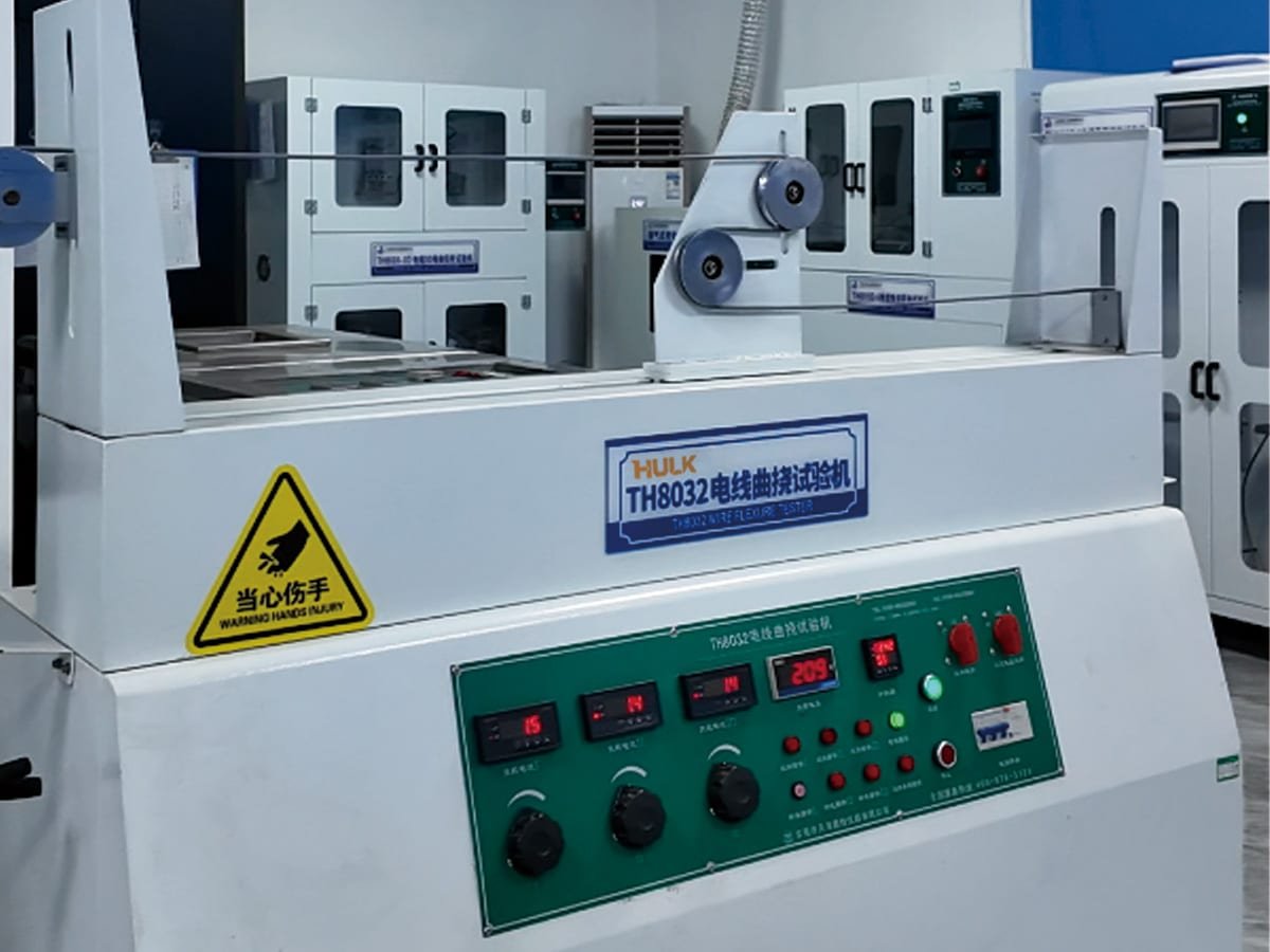 HULK TH8032 wire flexure tester in the lab, performing high-frequency reciprocating bending tests to validate cable durability for dynamic applications like drag chains and robotics.