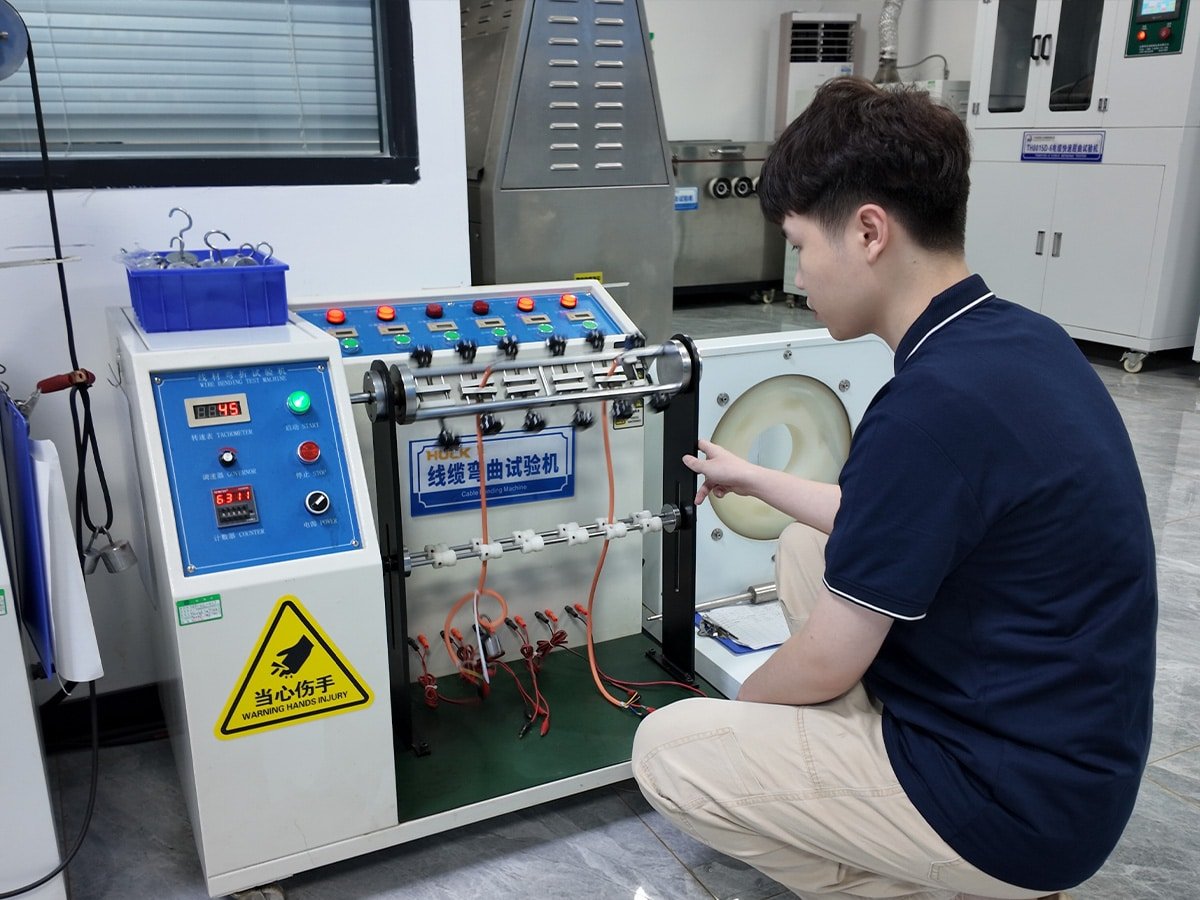 HULK technician setting up a cable bending fatigue tester to simulate repeated flexing and twisting motions, evaluating the mechanical durability and structural integrity of cables under dynamic stress conditions.