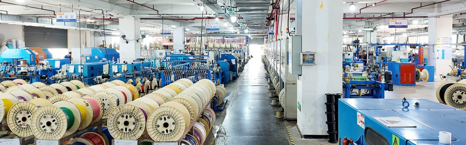 Panoramic view of the HULK manufacturing facility, showcasing multiple parallel production lines and organized cable reel storage, demonstrating large-scale production capacity and efficient supply chain management.