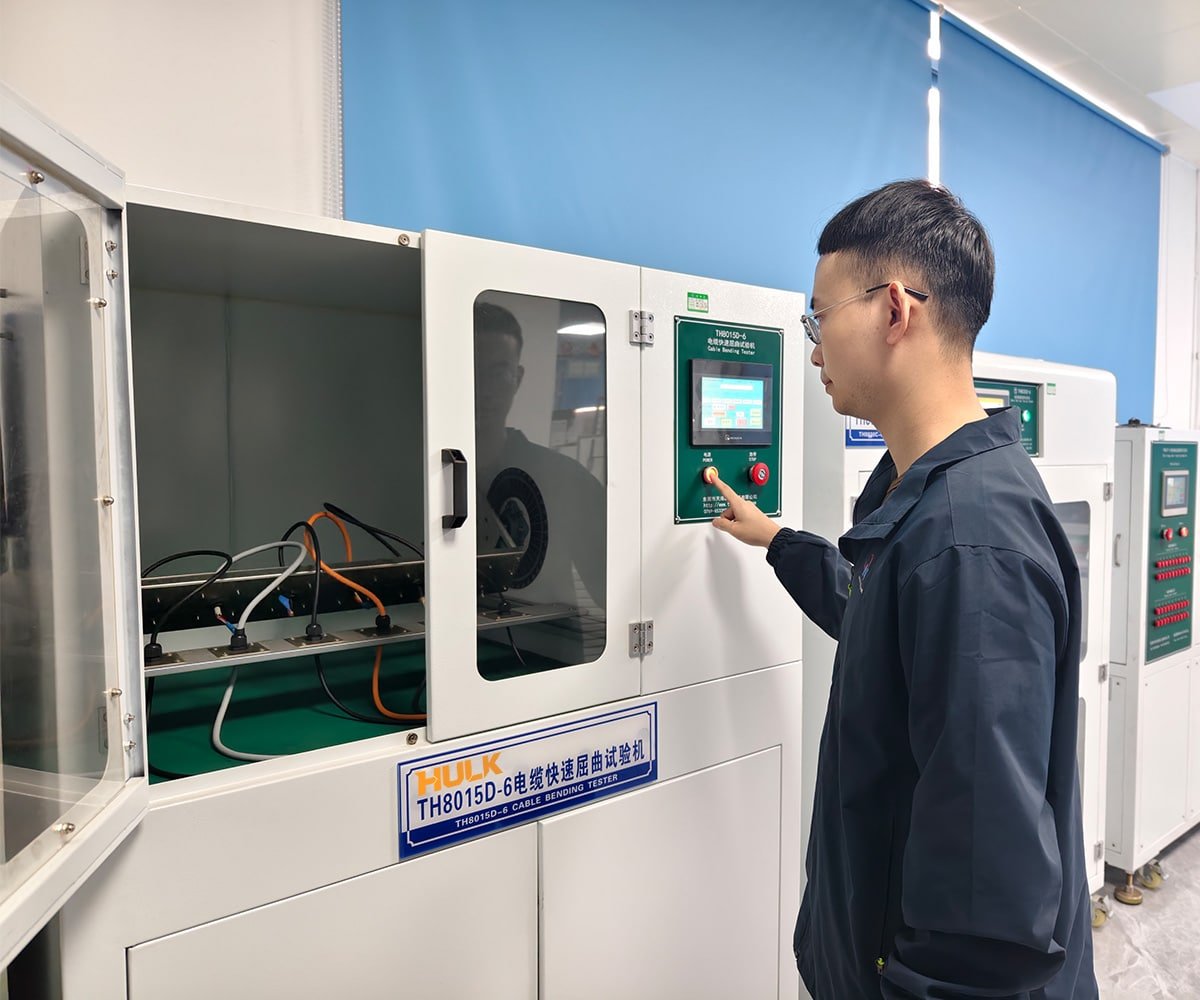 Technician operating HULK TH8015D-6 Cable Rapid Bending Tester in a quality control lab; multiple cables undergo high-frequency flexing tests to verify durability and fatigue resistance, ensuring HULK products meet rigorous standards for industrial applications.