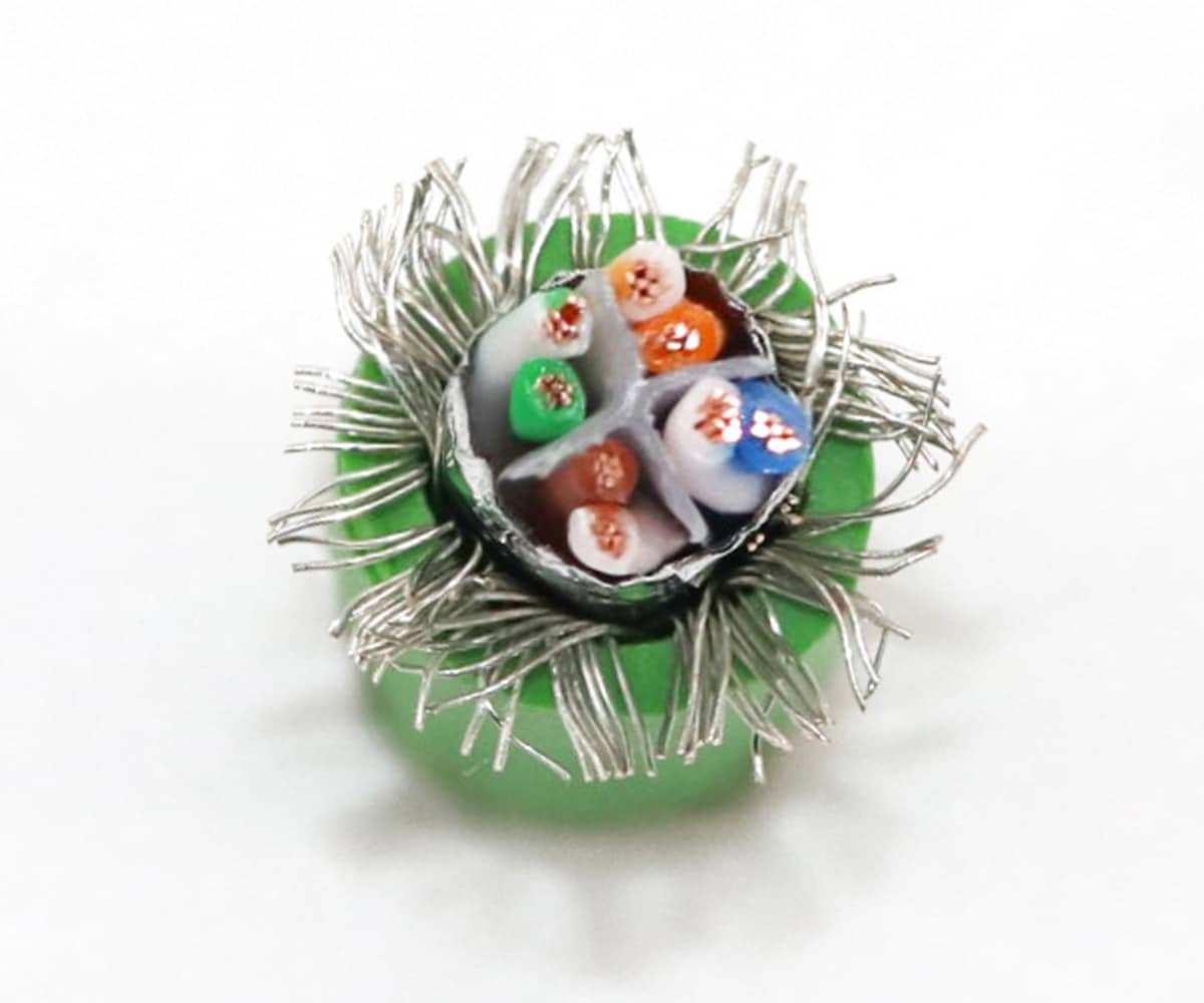 Cross-section of HULK industrial shielded data cable showing color-coded insulated conductors (orange, green, blue, brown) surrounded by dense silver braided shielding layer and green outer jacket — engineered for superior EMI/RFI rejection and signal integrity in high-noise automation environments.