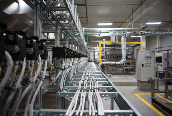 Close-up view of bundled halogen-free LSZH cables routed along cable trays in a clean, well-lit industrial automation plant near control panels, highlighting safety and professional installation for food processing and manufacturing environments
