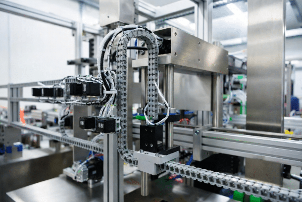 Professional view of packaging assembly machine featuring short-stroke drag chains supplying power and signal cables to servo motors and sensors in a high-speed industrial setting
