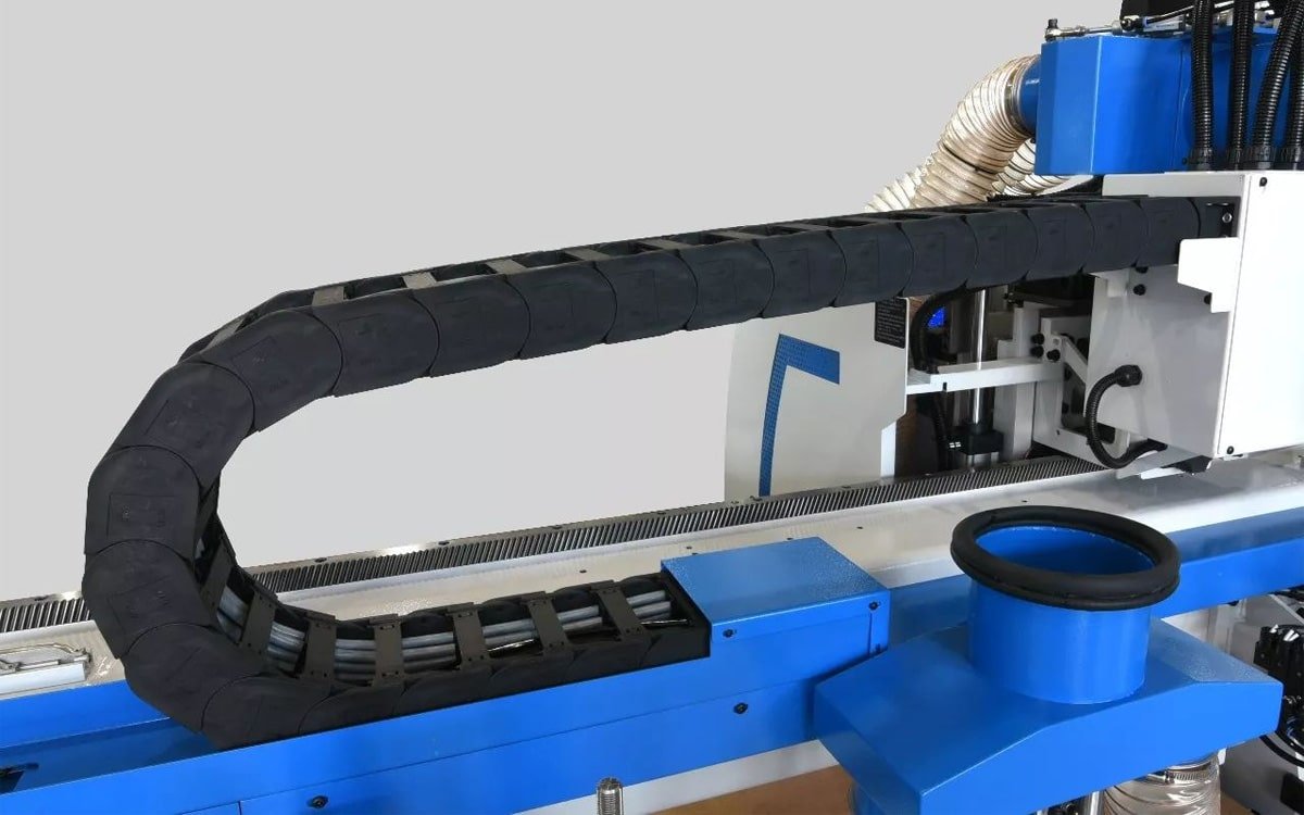 Hulk Cable enclosed drag chain system on CNC machining center, protecting gray cables with U-shaped bending motion for high-precision industrial automation