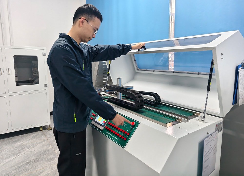 Hulk Cable engineer operating a drag chain cable bending fatigue tester in a lab, with control panel and sample cable installed, demonstrating rigorous durability validation for industrial motion cables