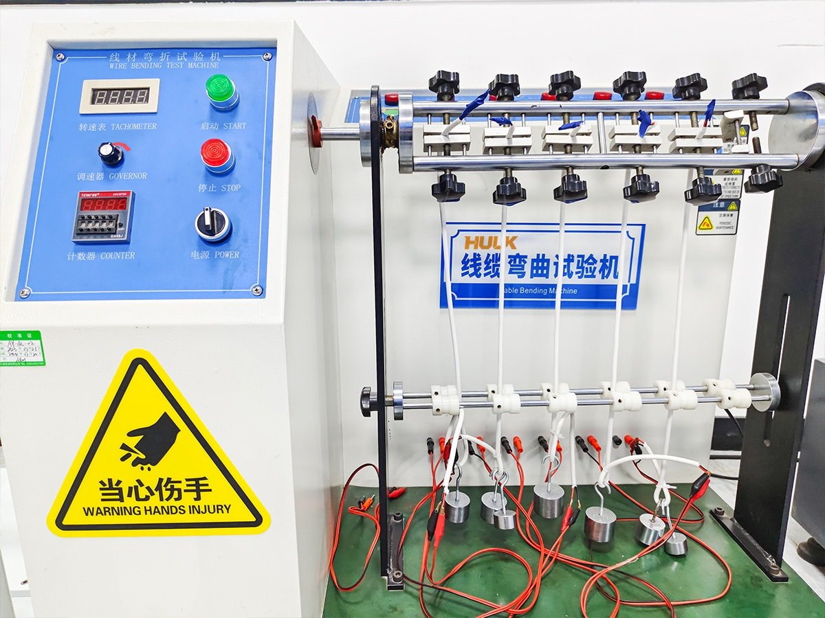 Hulk Cable Wire Bending Test Machine with digital tachometer, counter, and start/stop controls, performing standardized fatigue testing on multiple white cables to validate durability under repeated bending cycles