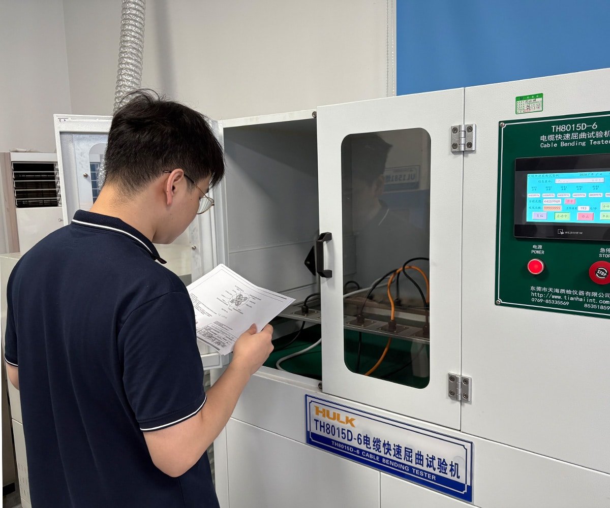Hulk Cable quality control scene showing technician reviewing test report beside TH8015D-6 cable bending tester, validating high-flex cable durability under repeated motion cycles
