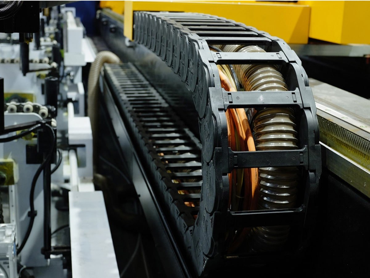 Hulk Cable heavy-duty drag chain cabling solution for multi-core power and signal cables in large-scale automation equipment, featuring orange and transparent sheathed cables routed inside black engineering plastic chain for stable transmission under high acceleration and oil exposure