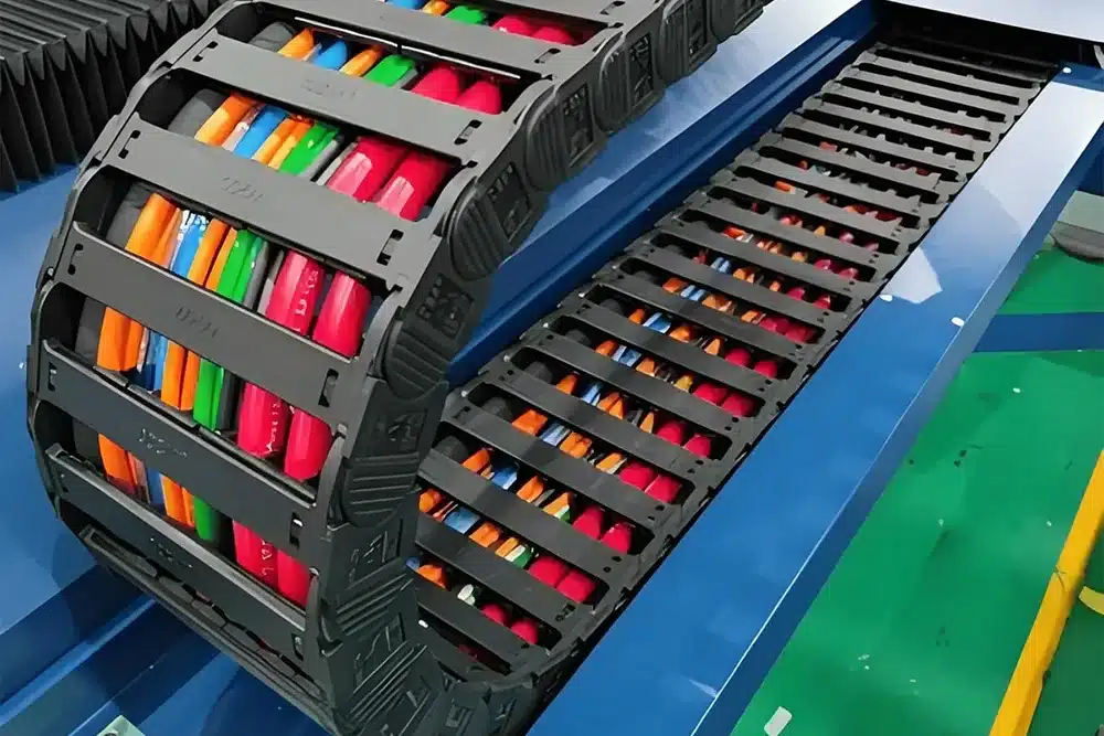 Hulk Cable heavy-duty bridge-type plastic drag chain system with multi-colored cables organized inside, designed for high-frequency motion protection in CNC machines and automated production lines