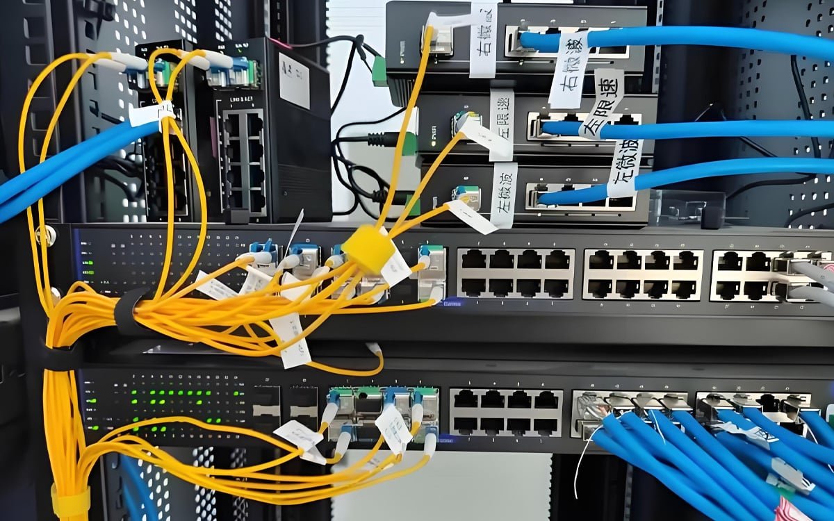 Hulk Cable high-density Ethernet cabling system in industrial network cabinet, featuring blue and yellow shielded cables connected to managed switches with labeled ports for real-time industrial automation and data center applications