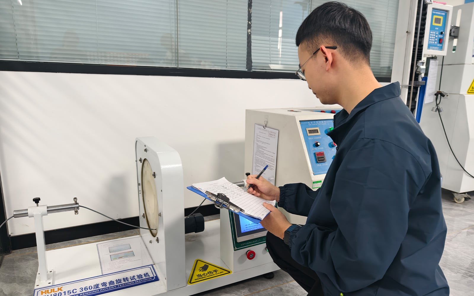 Hulk Cable lab technician recording data from TH8015C 360-degree bending rotary tester, validating cable durability under full-range rotational stress with manual and digital verification