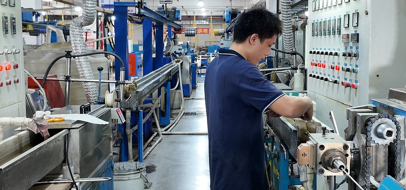 Hulk Cable manufacturing workshop showing a technician monitoring the cable extrusion process on an automated production line, ensuring precision quality control and operational safety in industrial cable manufacturing