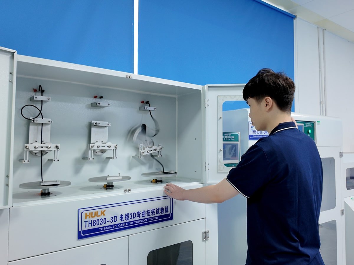 Hulk Cable quality control lab technician operating the TH8030-3D Cable 3D Torsion Tester to perform durability testing on high-flex cables, simulating complex robotic movements to ensure millions of bending cycles reliability